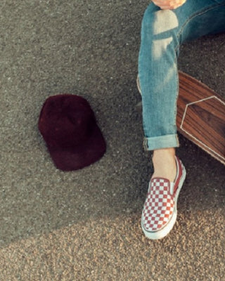 Tanara cu espadrile Vans tinand picioarele pe o placa de skateboard