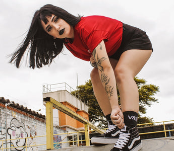 Tanara in tricou rosu pe un traseu de skateboard