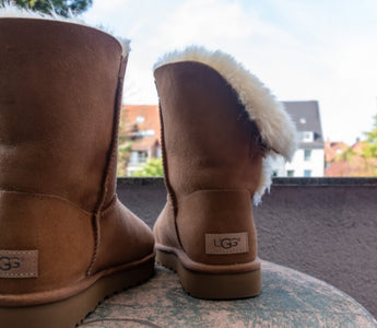 Cizme Ugg asezate pe masa rotunda, pe balconul unei case