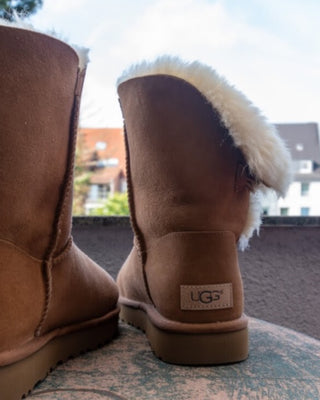 Cizme Ugg asezate pe masa rotunda, pe balconul unei case