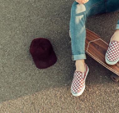 Tanara cu espadrile Vans tinand picioarele pe o placa de skateboard