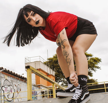 Tanara in tricou rosu pe un traseu de skateboard