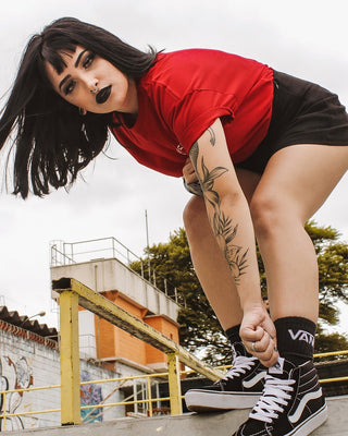 Tanara in tricou rosu pe un traseu de skateboard
