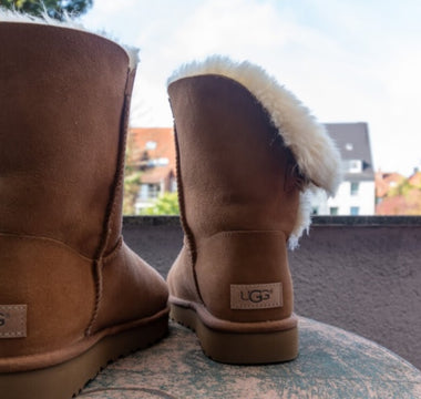 Cizme Ugg asezate pe masa rotunda, pe balconul unei case